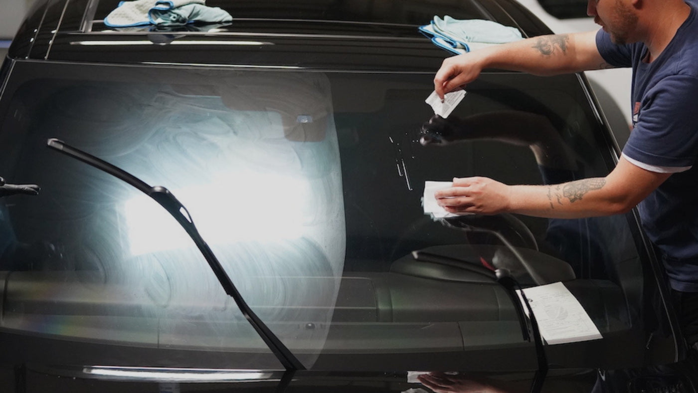 professional detailer applying a hydrophobic windshield coating and glass treatment