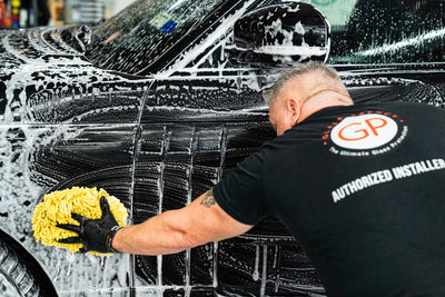 Washing black car with GlassParency S2 Soap suds and a microfiber sponge