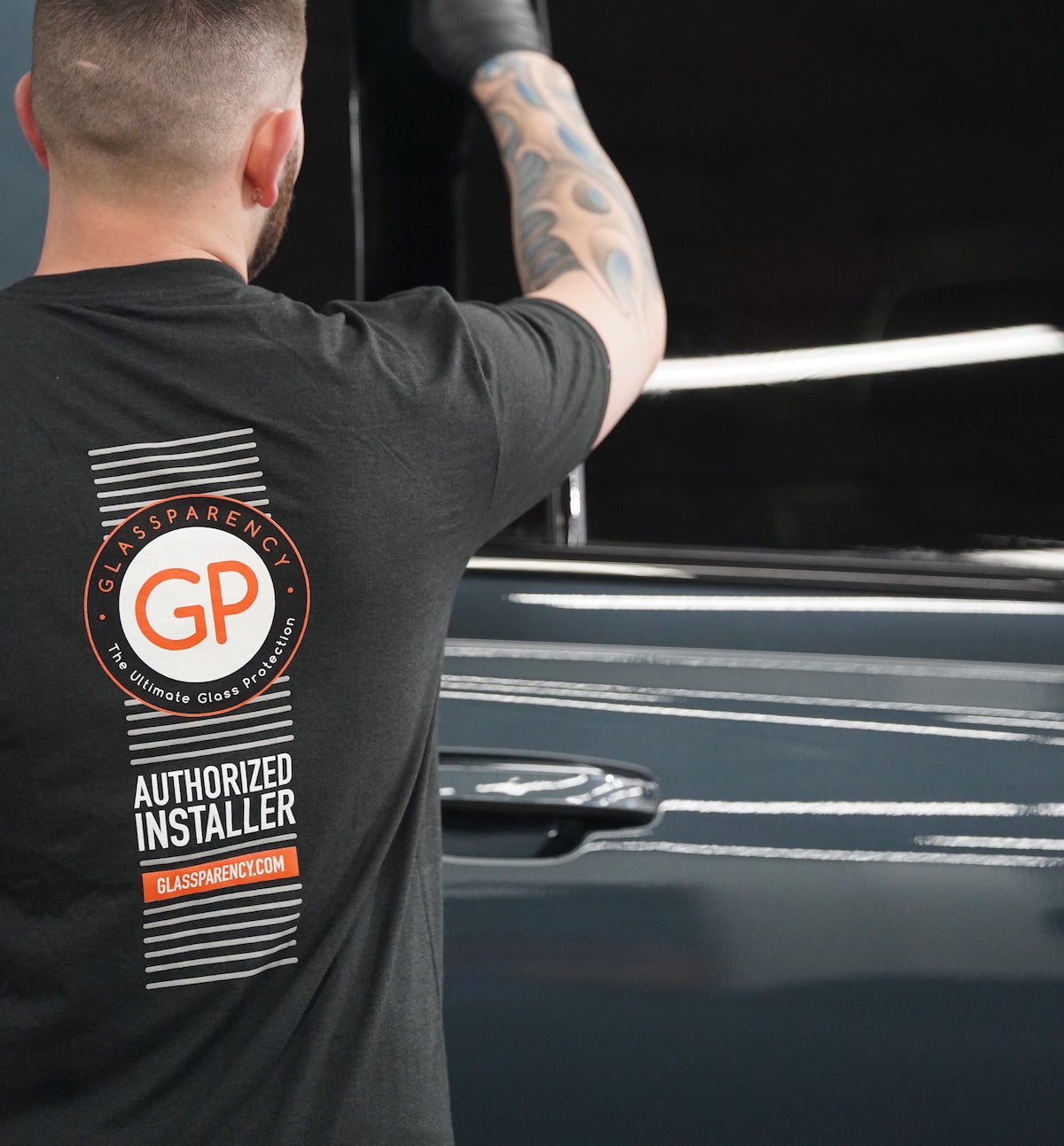 glassparency authorized installer wearing authorized installer t-shirt applying windshield treatment